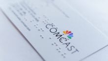 A Comcast business card covered in Braille.