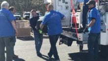 Comcast Cares Day volunteers unload a truck with electronics.
