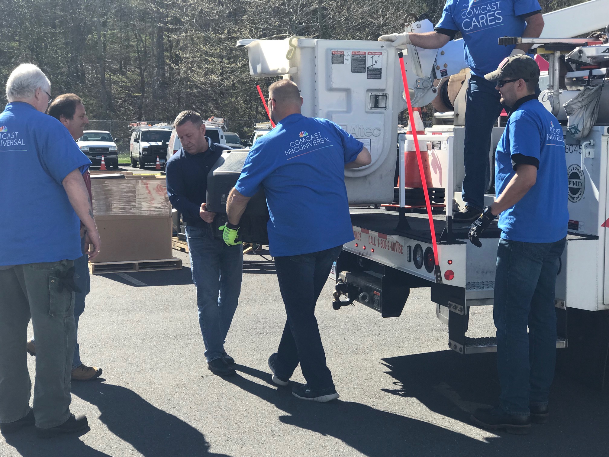 Comcast Cares Day volunteers unload a truck with electronics.