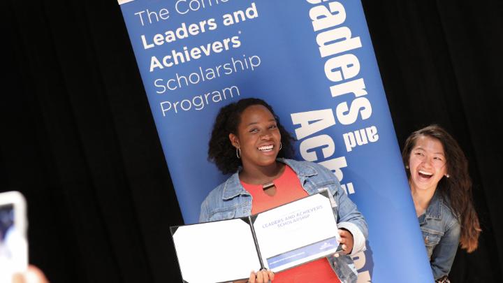 Leaders and Achievers winners pose in front of a poster