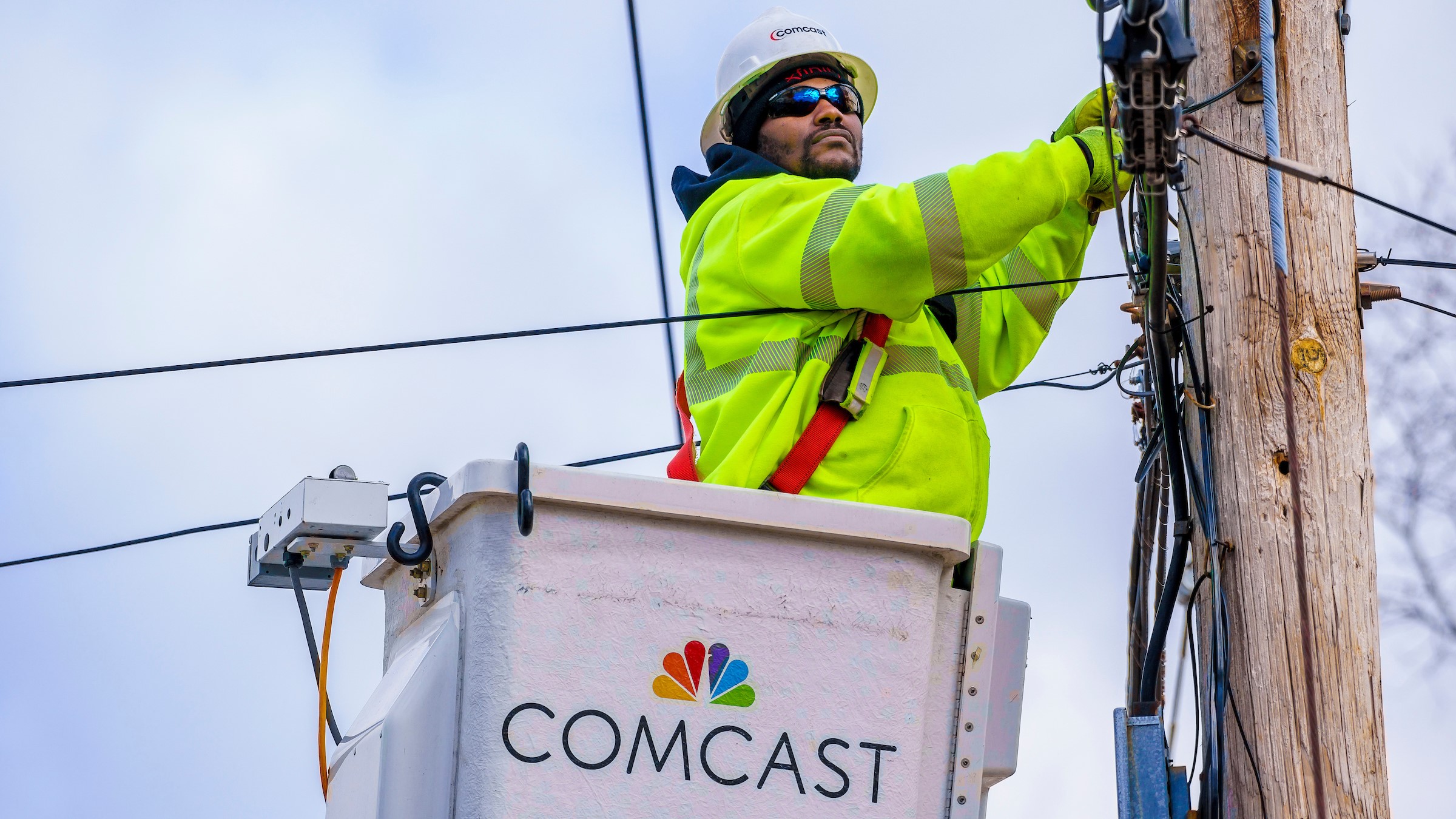 A Comcast technician repairs a cable