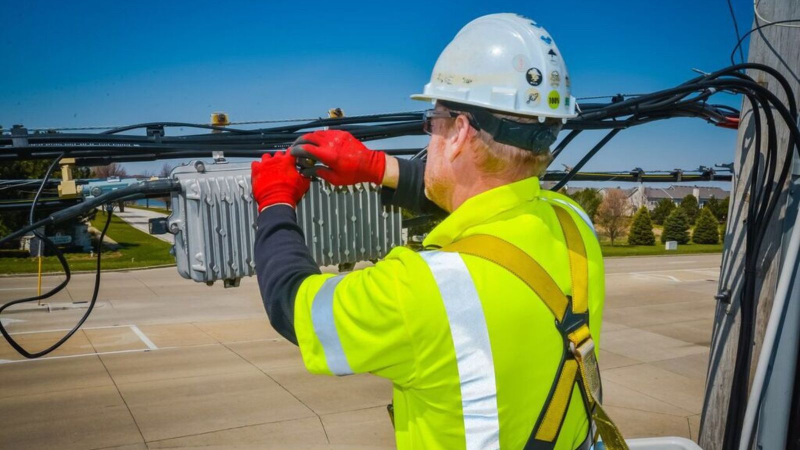 Technician wearing hard hat and working on cables